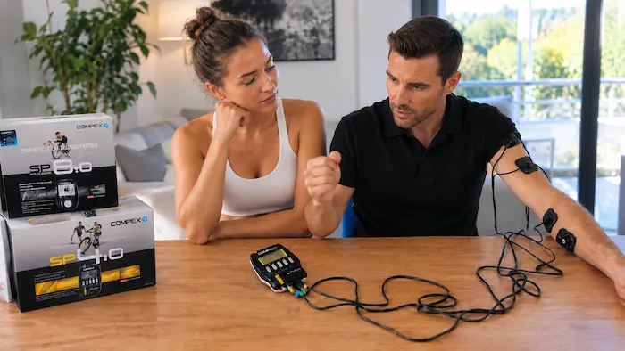 Électrostimulateur Compex SP&nbsp;4.0 avec ses électrodes placées sur le biceps